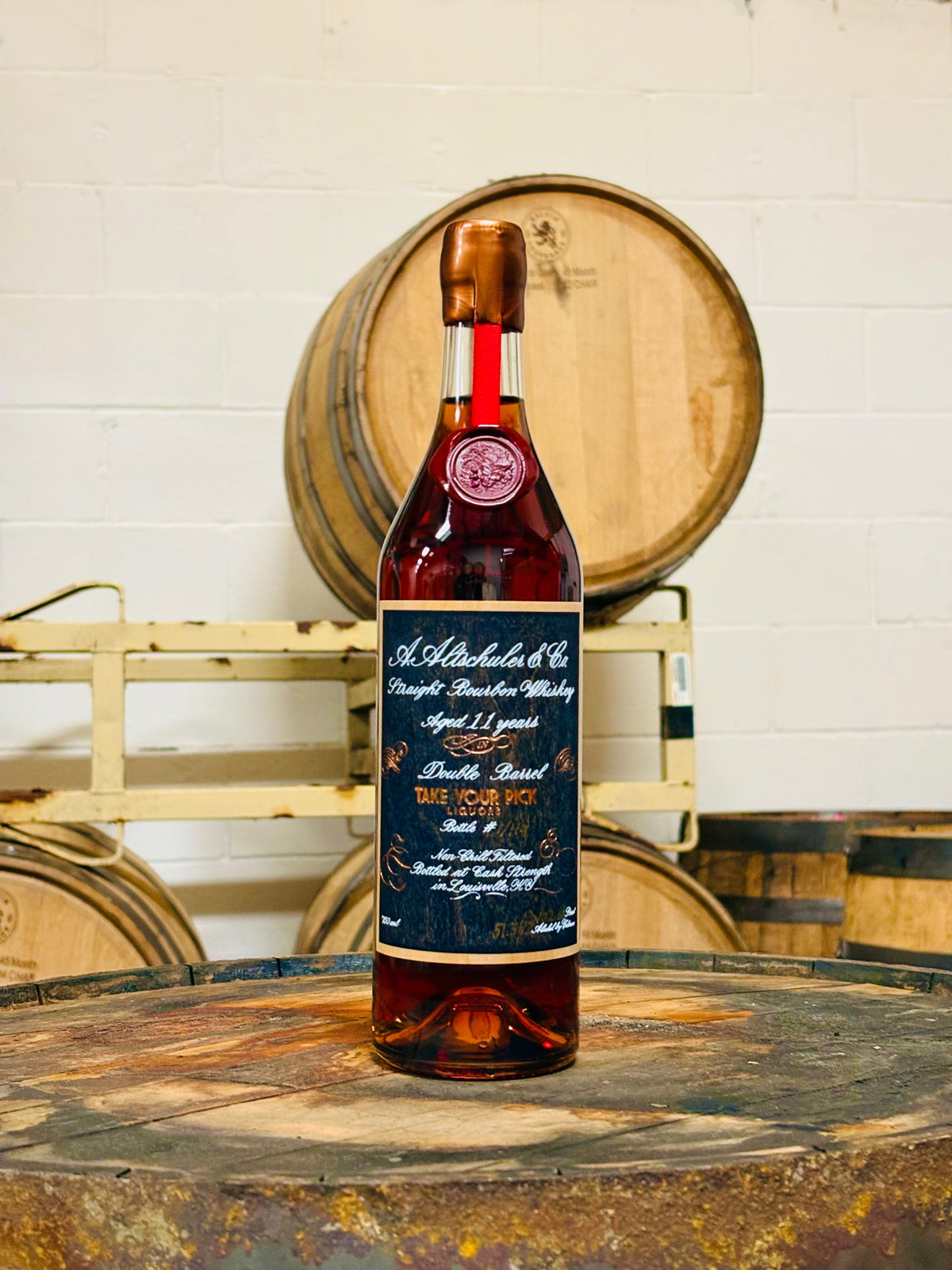 Aged 11-year Straight Bourbon Whiskey bottle on wooden barrel, Double Barrel, Take Your Pick Liquors